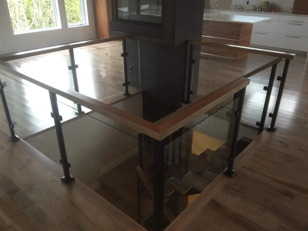 Garde-corps de verre et main courante de bois au niveau principal