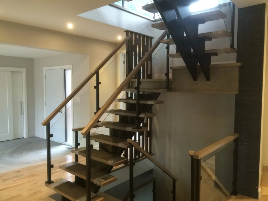 Volee de l'escalier vers l'etage, marches ouvertes et poteaux d'acier noir
