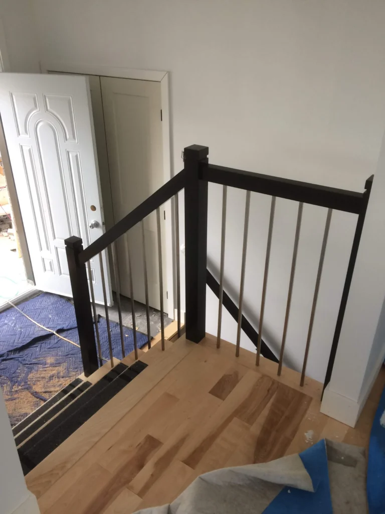 Garde-corps contemporain à barreaux d&rsquo;inox et bois foncé, en chantier