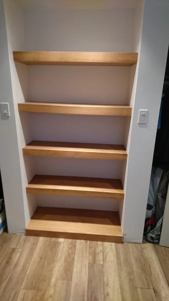Tablettes flottantes de bois dans une niche murale
