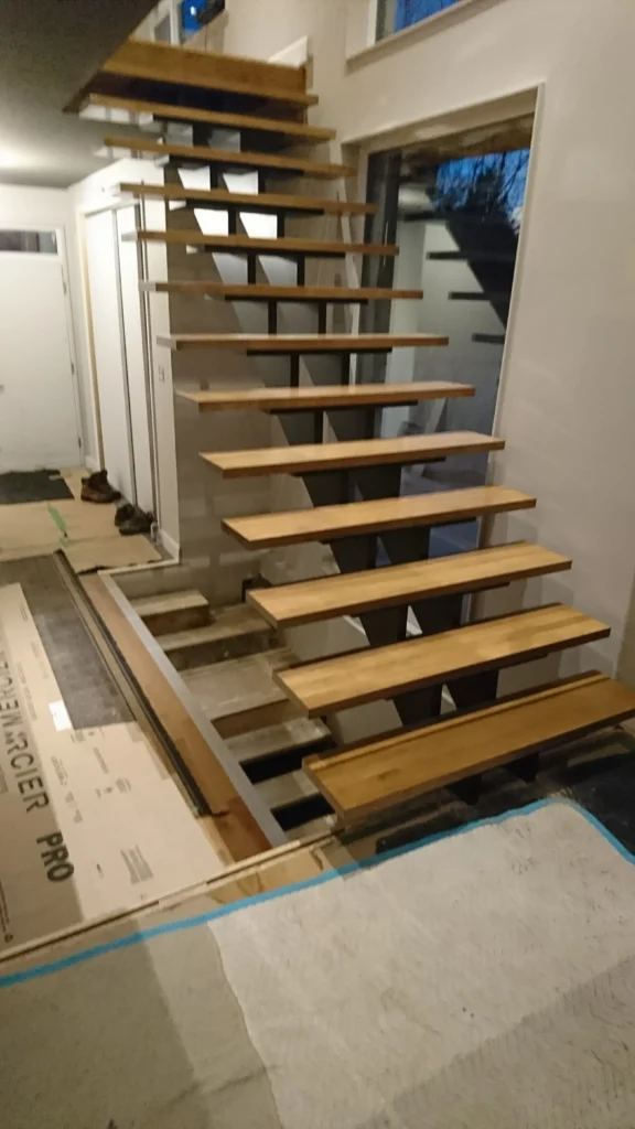 Escalier suspendu à limon central d&rsquo;acier et marches de bois blond