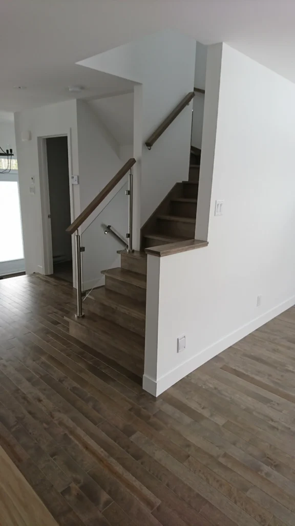 Escalier tournant en érable gris, verre et inox sur plusieurs niveaux