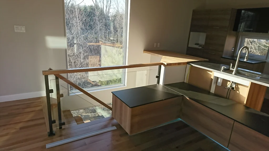 Escalier ouvert et garde-corps de verre dans une aire décloisonnée