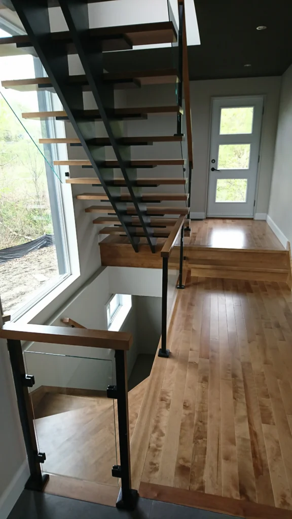 Escalier tournant avec palier et garde-corps de verre