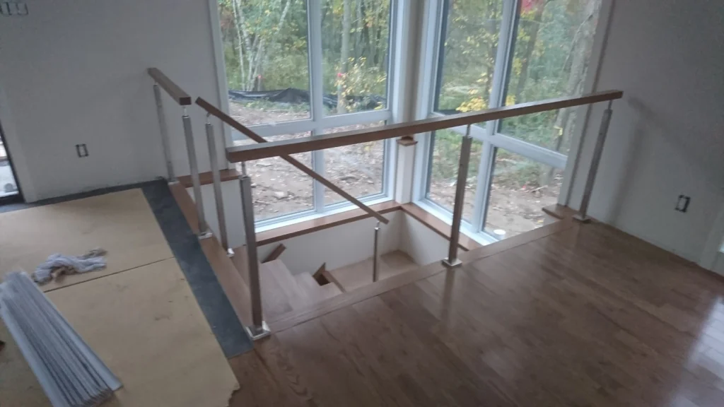 Escalier tournant à garde-corps de verre sur mezzanine