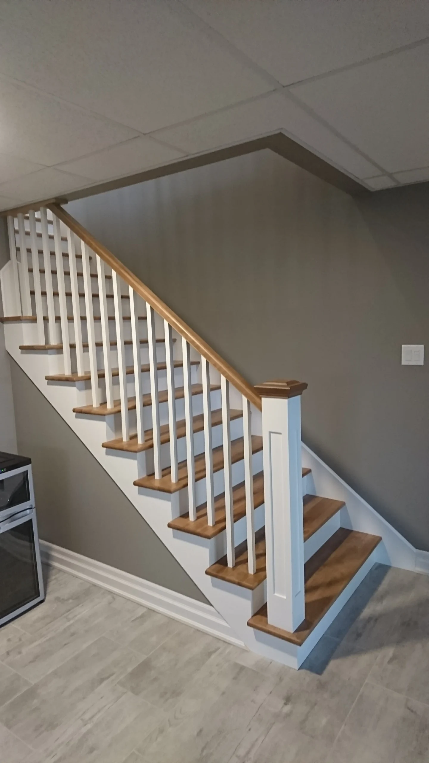 Escalier droit en bois franc à contremarches blanches et barreaux tournés — vue principale