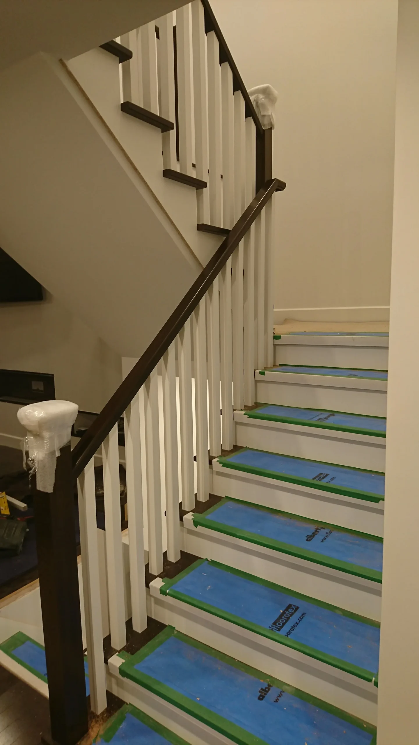 Escalier tournant à barreaux blancs et main courante de bois foncé — vue principale