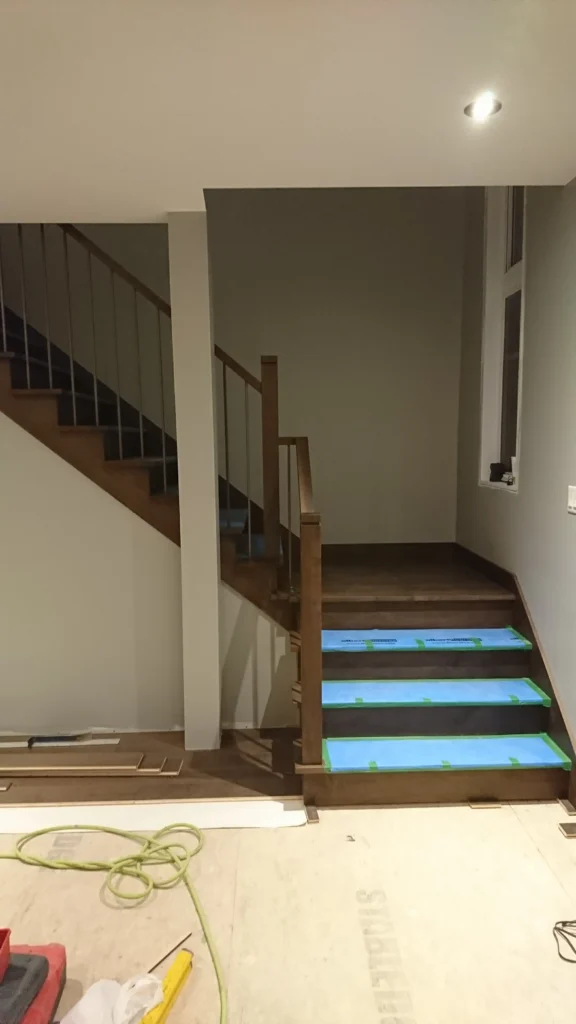 Escalier tournant en bois foncé à barreaux de métal noir