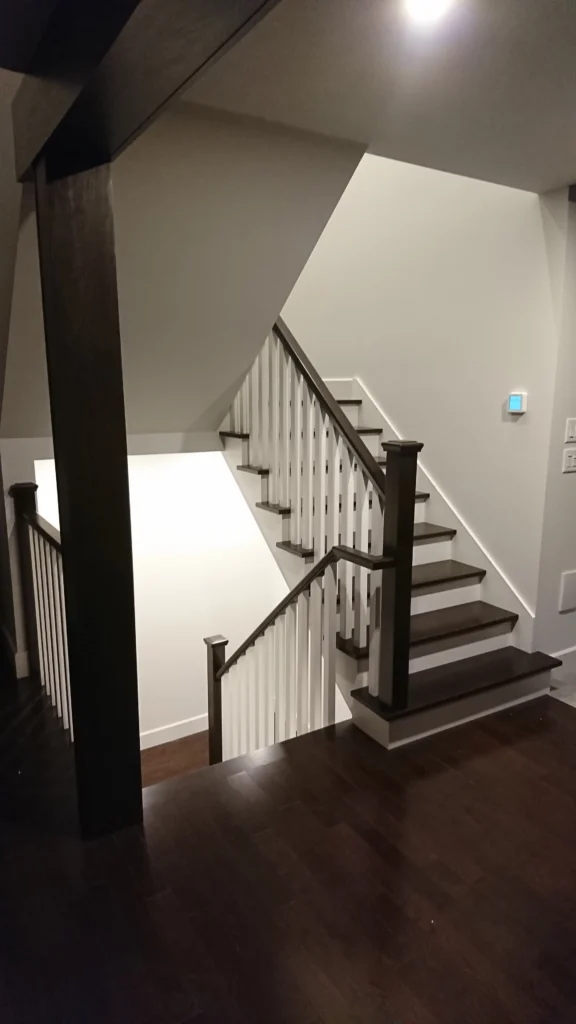 Escalier tournant bicolore en bois foncé avec barreaux tournés blancs — vue 4