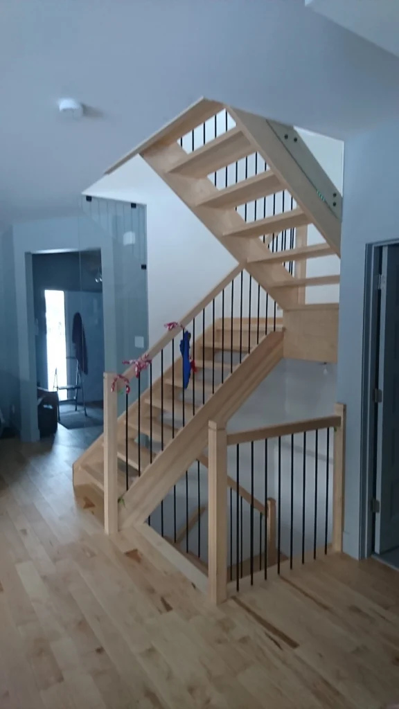 Escalier tournant à contremarches ouvertes en bois d'érable avec garde-corps de verre — vue 1