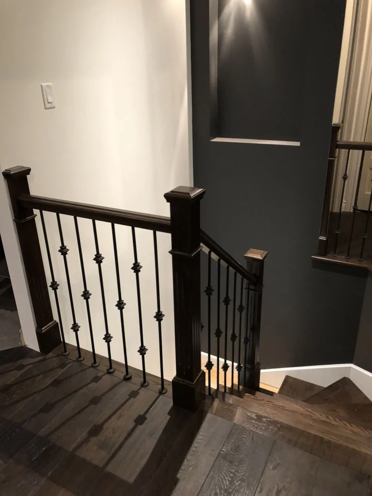 Escalier tournant en bois foncé avec barreaux de fer forgé — vue 3