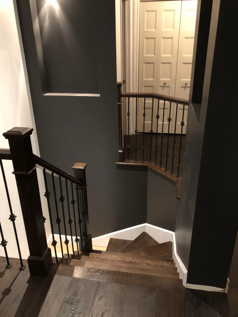Escalier tournant en bois foncé avec barreaux de fer forgé — vue 4