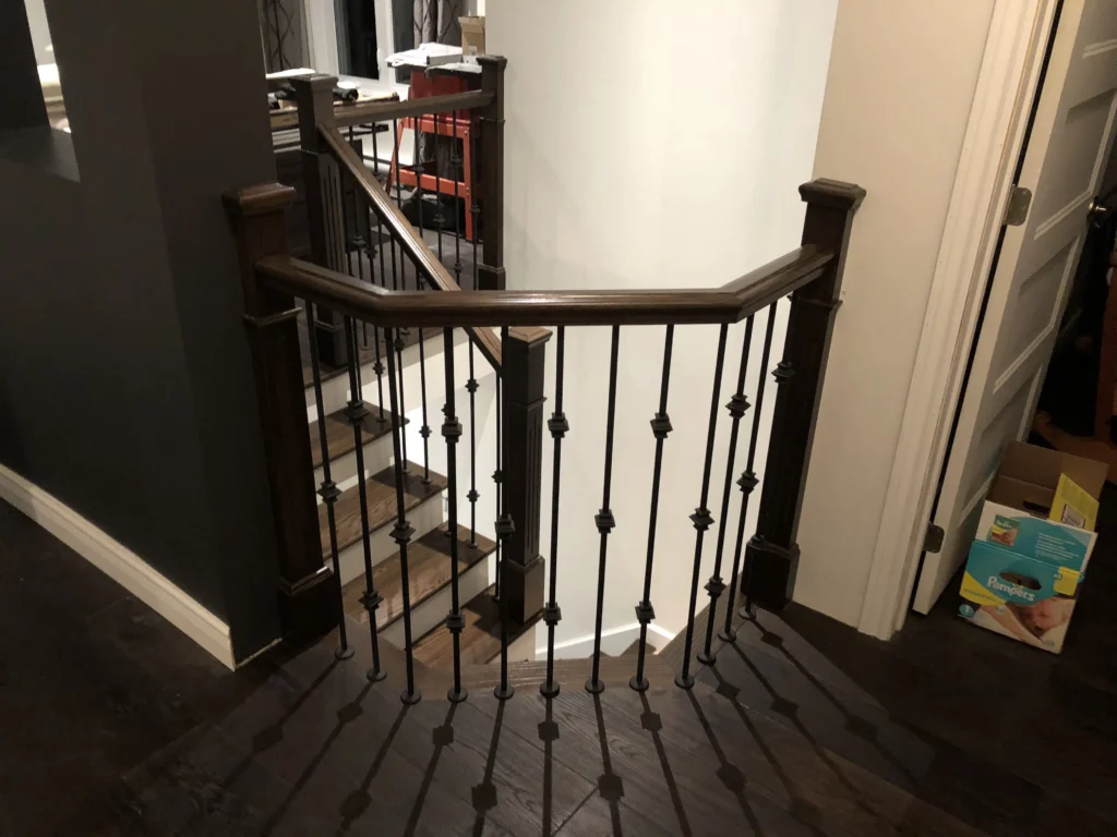 Escalier tournant en bois foncé avec barreaux de fer forgé — vue 5