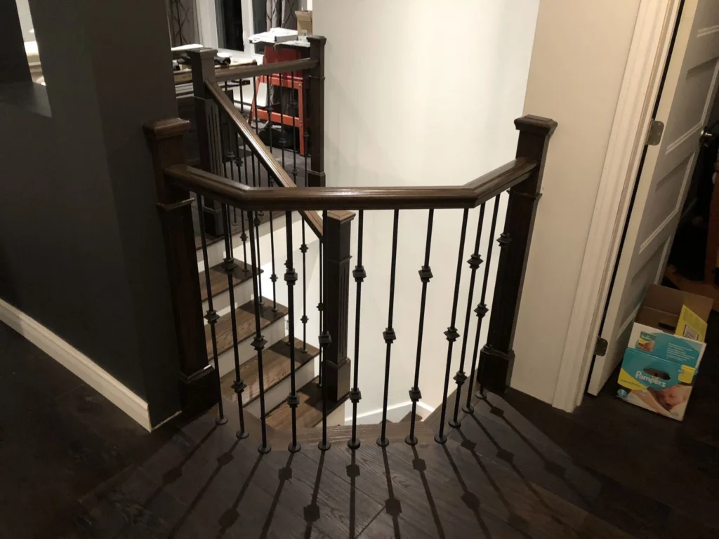 Escalier tournant en bois foncé avec barreaux de fer forgé — vue 6