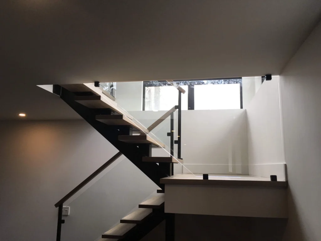 Escalier suspendu à contremarches ouvertes avec limons d'acier et garde-corps de verre — vue 3