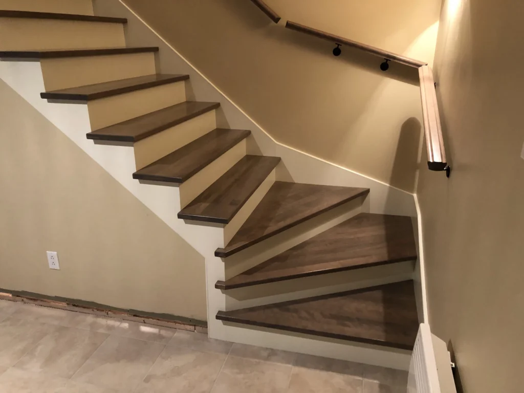 Escalier tournant en bois gris-brun à main courante murale