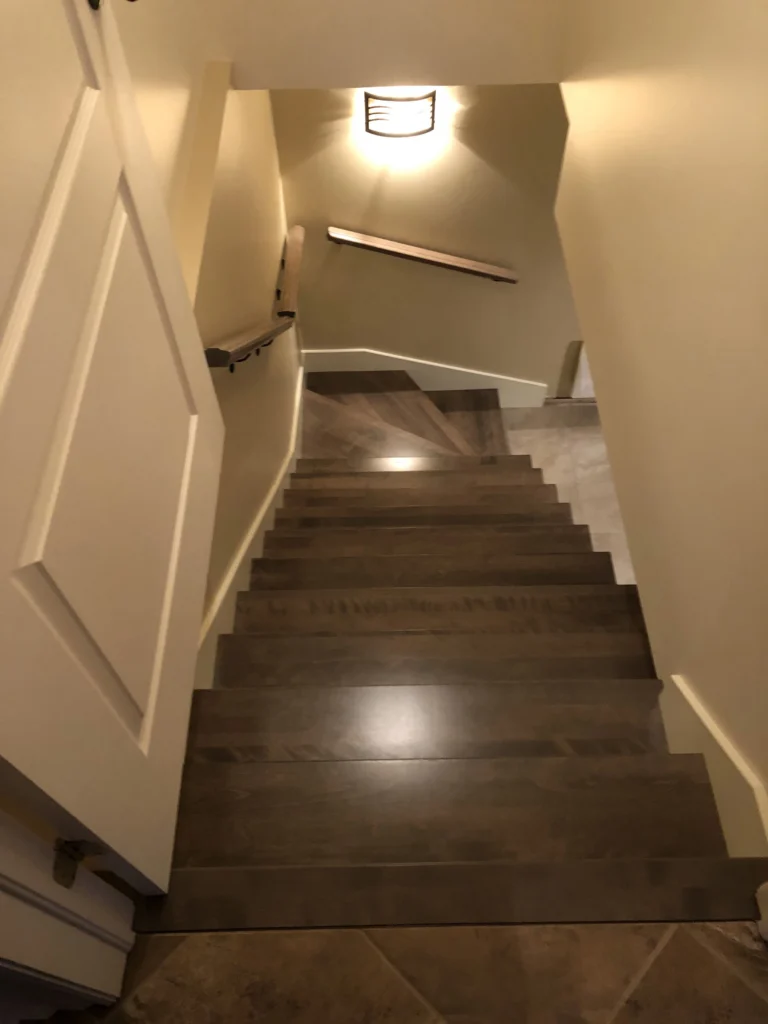 Escalier tournant en bois gris-brun avec main courante murale — vue 4