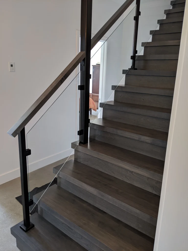 Escalier tournant gris-brun à garde-corps de verre et structure d'acier à Longueuil (vue 2)