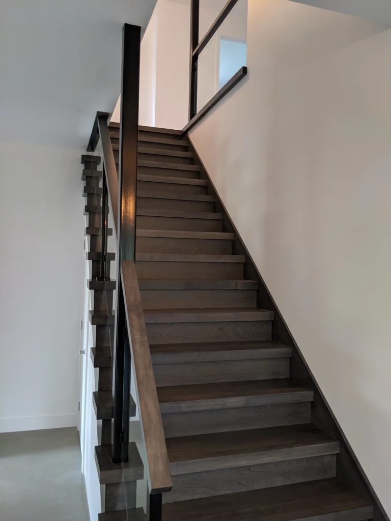 Escalier tournant gris-brun à garde-corps de verre et structure d'acier à Longueuil (vue 8)