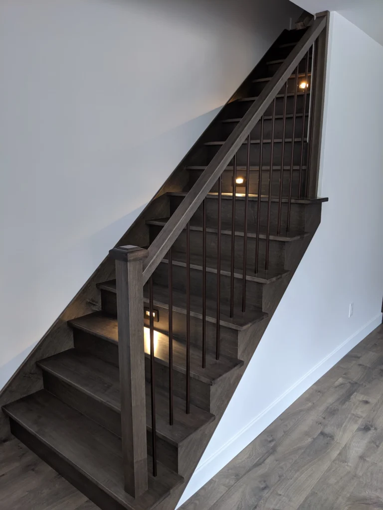 Escalier tournant gris-brun à fins barreaux de métal noir
