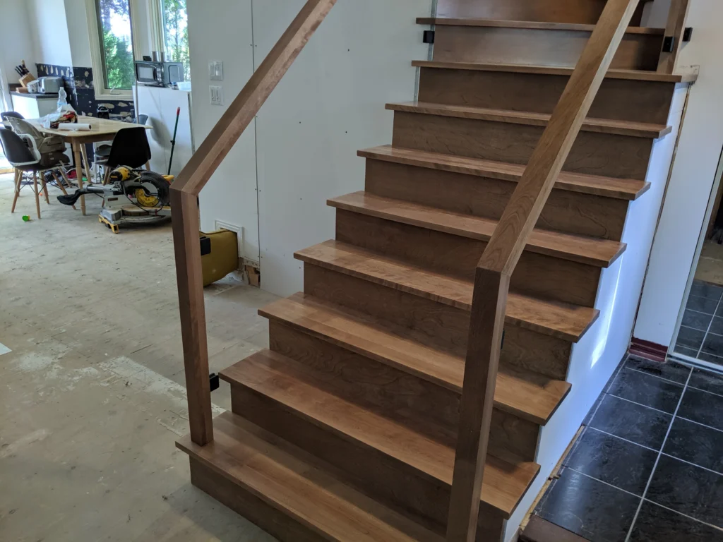 Escalier tournant de bois franc au ton miel et garde-corps de verre à Boucherville