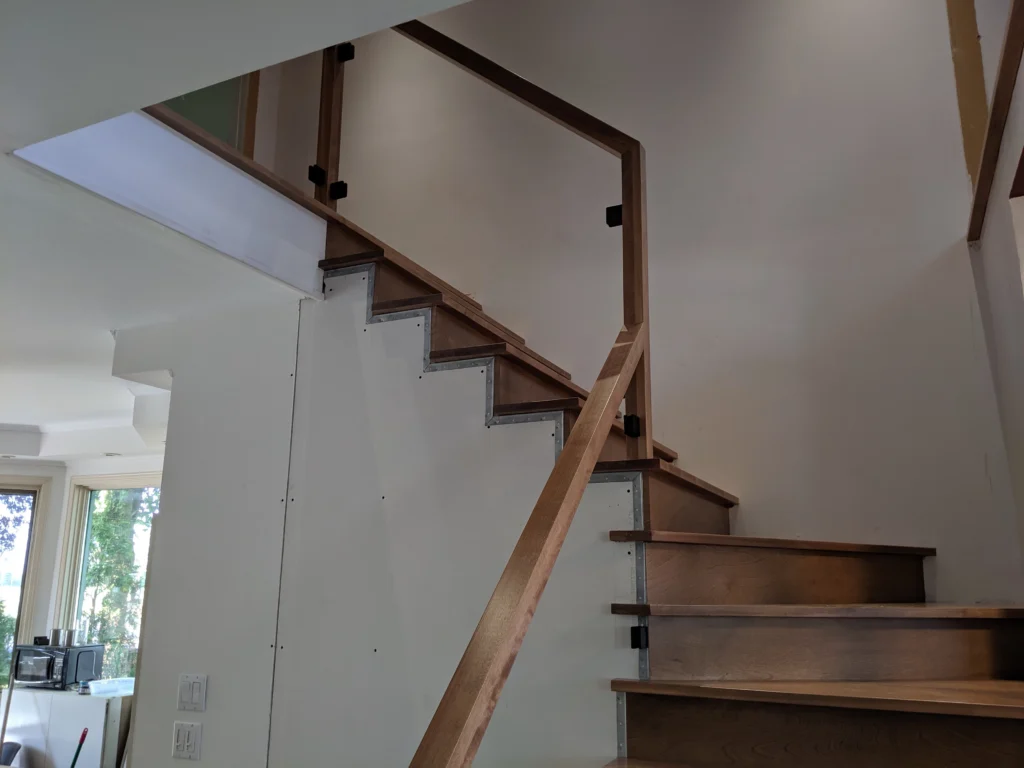 Escalier tournant de bois franc au ton miel et garde-corps de verre à Boucherville (vue 4)