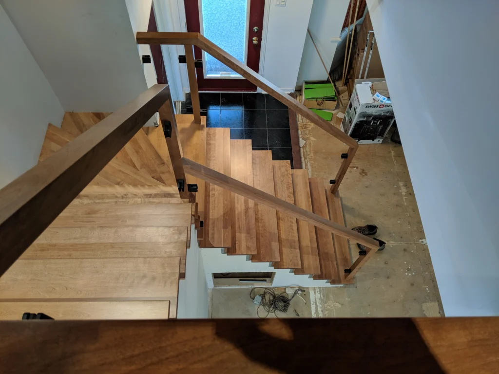 Escalier tournant de bois franc au ton miel et garde-corps de verre à Boucherville (vue 7)