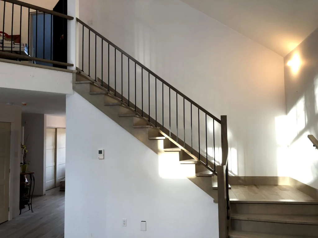 Escalier tournant de bois blond-gris à barreaux de métal noir à Chambly (vue 3)