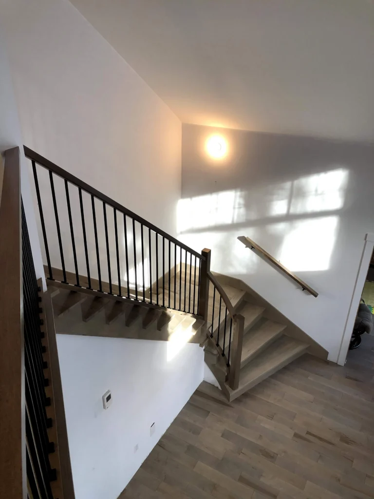 Escalier tournant de bois blond-gris à barreaux de métal noir à Chambly (vue 6)