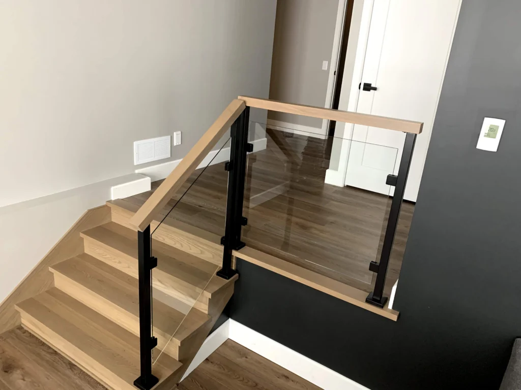 Escalier suspendu à marches de bois clair et garde-corps de verre à Magog