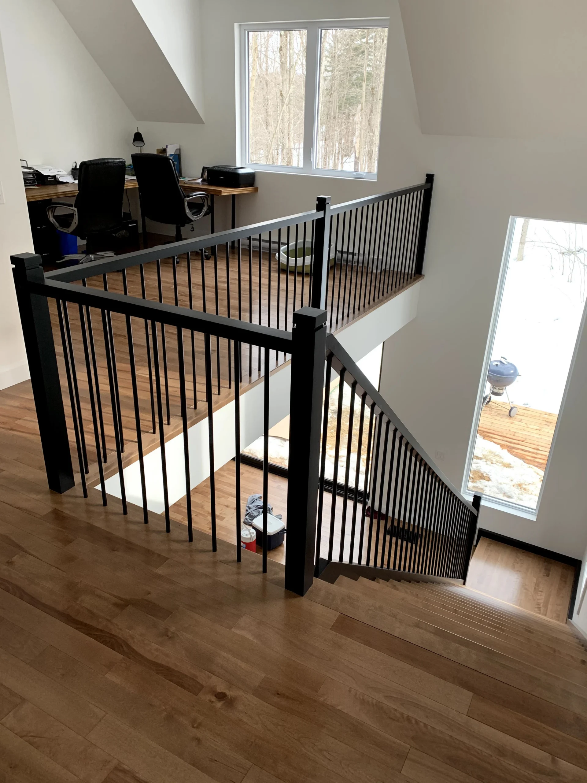 Escalier tournant de bois franc blond à garde-corps de métal noir — vue principale