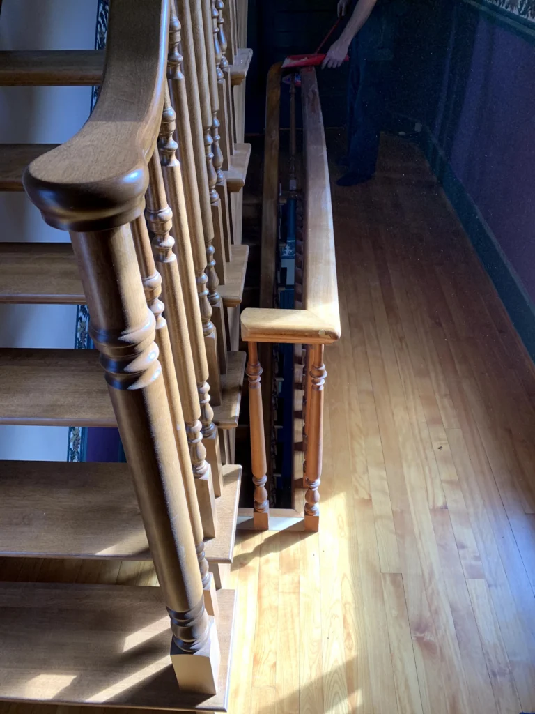 Escalier tournant de bois franc à barreaux tournés et contremarches ouvertes à Longueuil