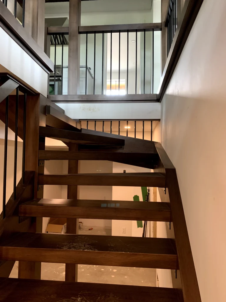 Escalier tournant en bois foncé aux marches rayonnantes vues d'en haut
