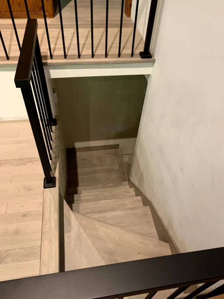 Escalier en bois blanchi et garde-corps métallique noir