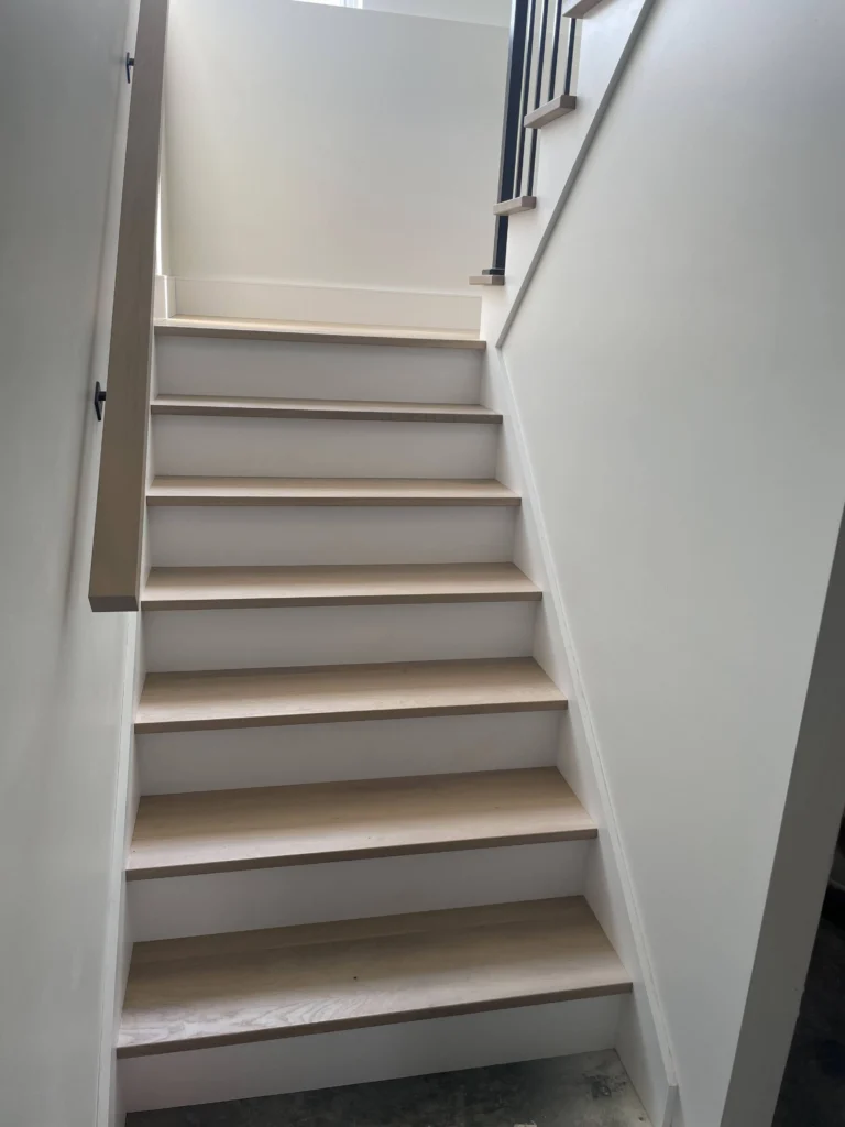 Escalier suspendu en chêne blanc à contremarches ouvertes avec structure d'acier noir