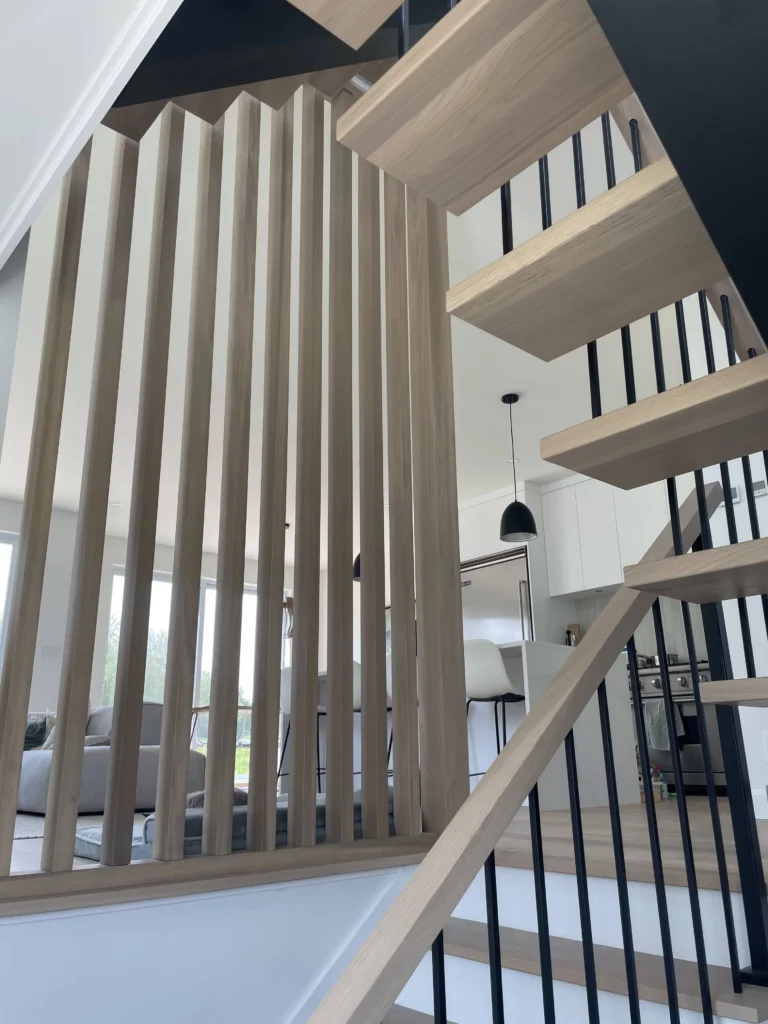 Escalier suspendu en chêne blanc avec claustra de bois et structure d&rsquo;acier noir