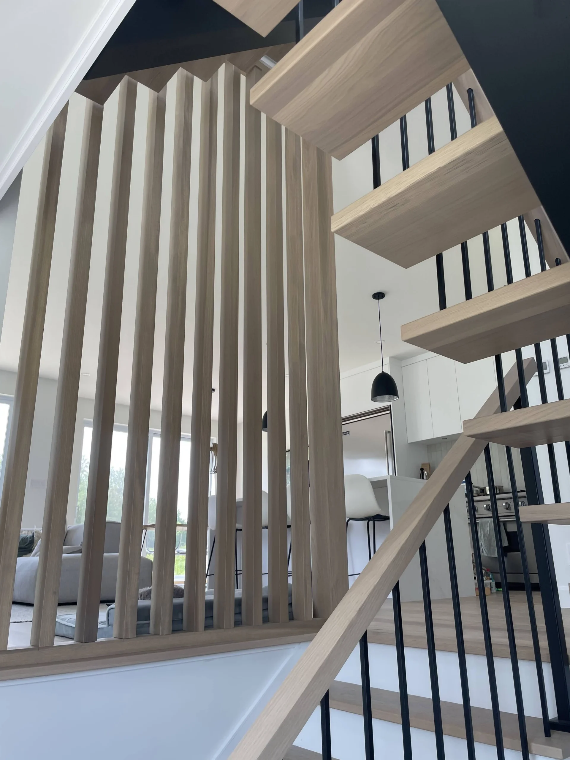 Escalier suspendu en chêne blanc avec claustra de bois et structure d&rsquo;acier noir — vue principale