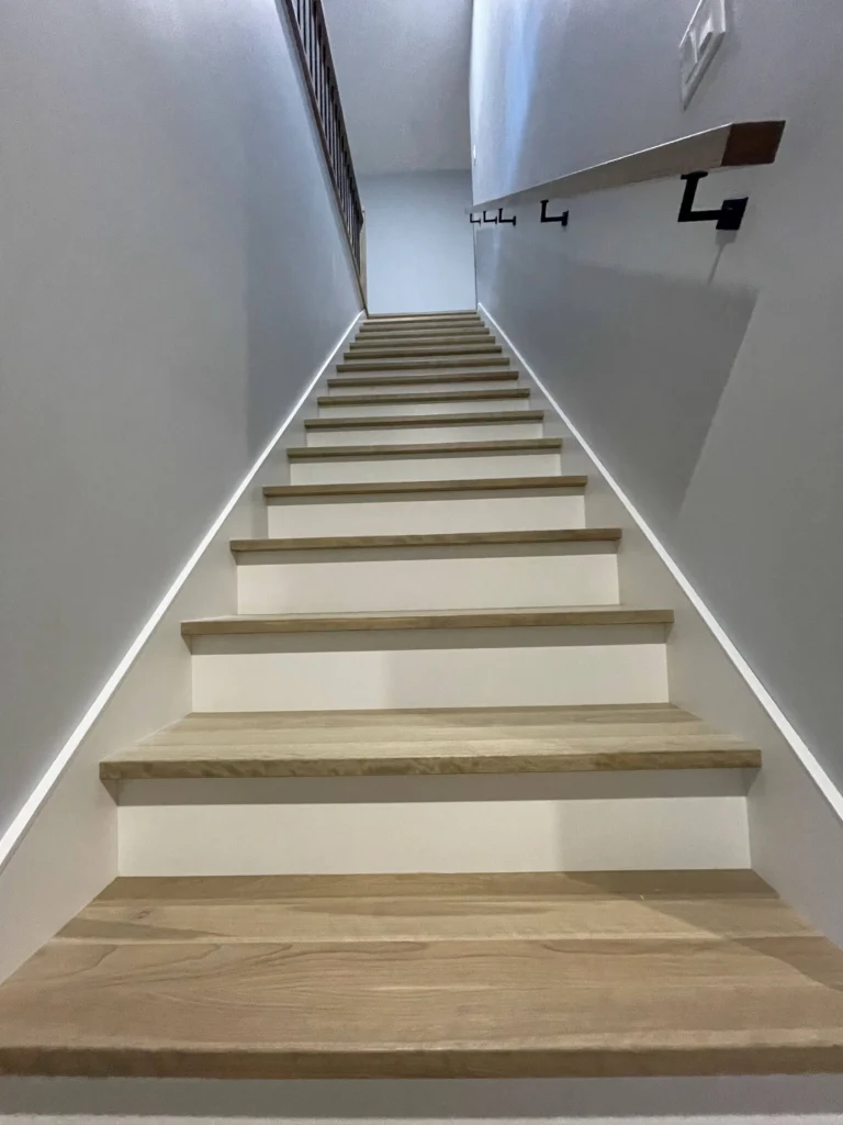 Escalier droit en bois clair avec éclairage à ruban DEL intégré