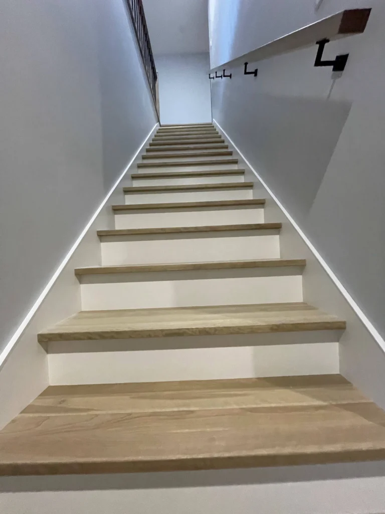 Marches de bois clair et contremarches blanches d'un escalier droit