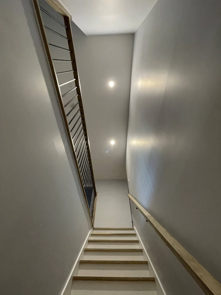 Palier d'escalier avec garde-corps à barres horizontales dans un cadre de bois
