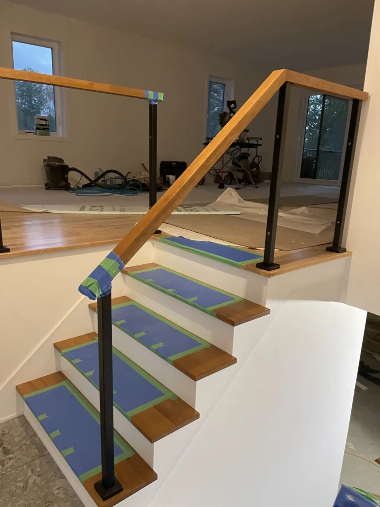 Marches de bois naturel et garde-corps de verre en cours d'installation
