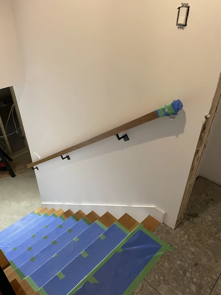 Vue plongeante sur un escalier tournant en bois naturel bordé de verre