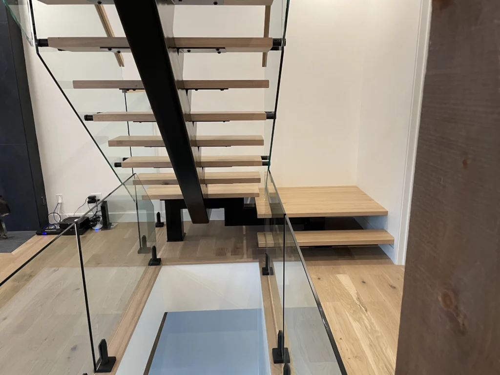 Escalier suspendu et garde-corps de verre dans une aire ouverte de chalet