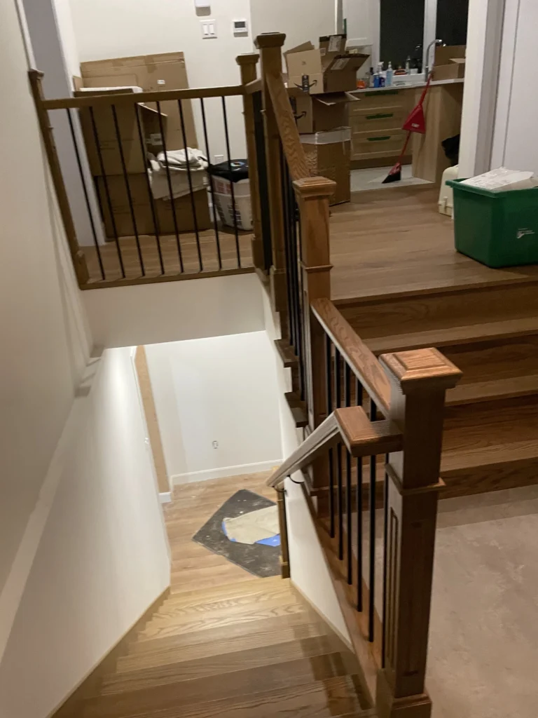 Escalier de chêne roux reliant plusieurs demi-niveaux avec garde-corps à barreaux métalliques