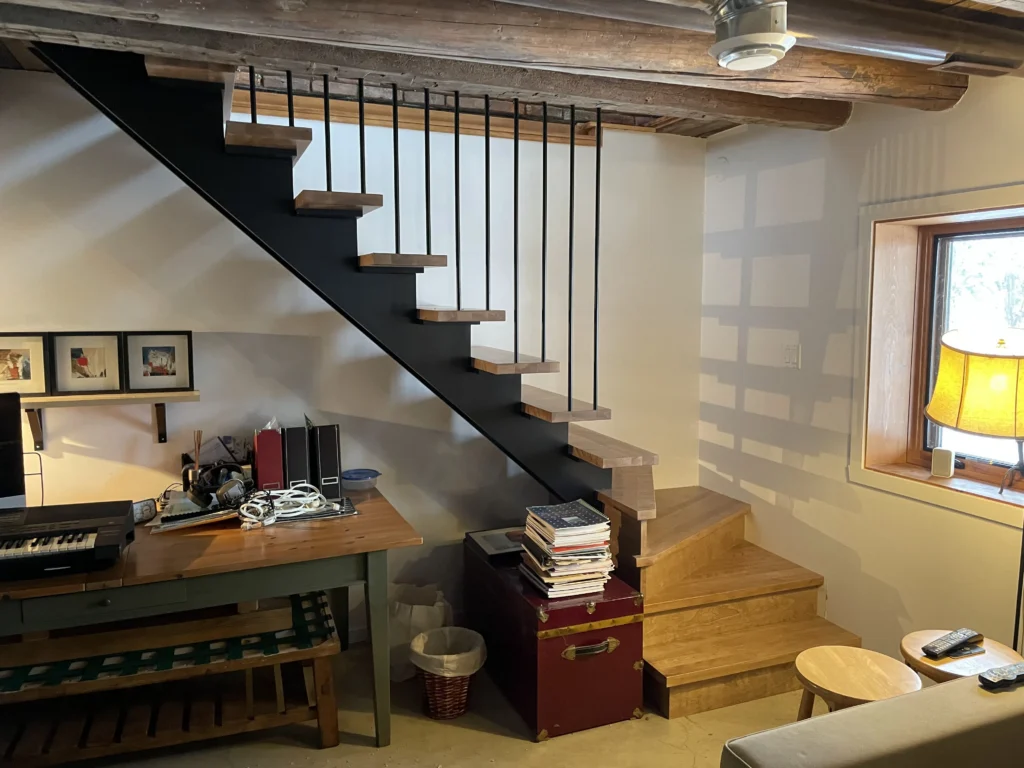 Escalier suspendu sur limon d&rsquo;acier avec marches de chêne et tiges verticales