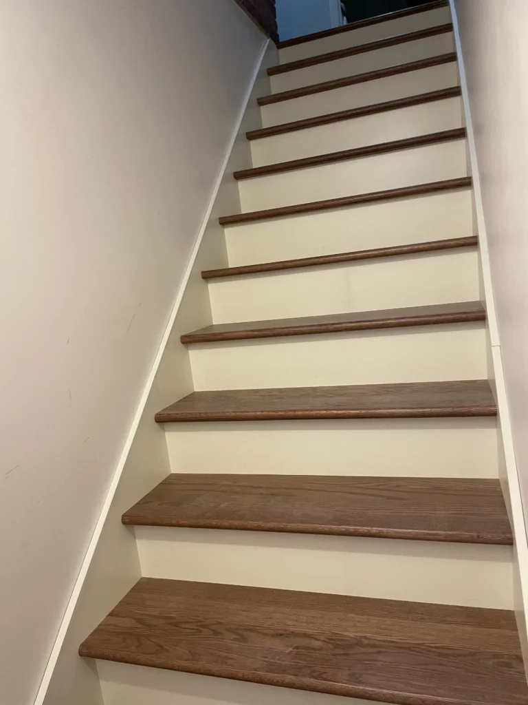 Escalier droit en bois franc teinté noyer aux contremarches blanches