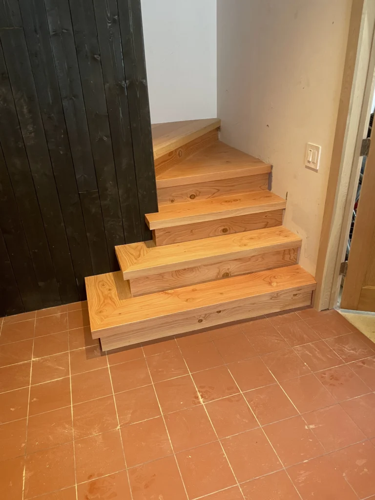 Bas de l'escalier tournant en pin, marches rayonnantes teinte miel à Brossard