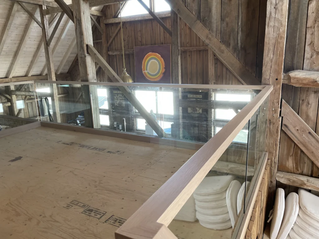 Mezzanine à garde-corps de verre encadré de bois
