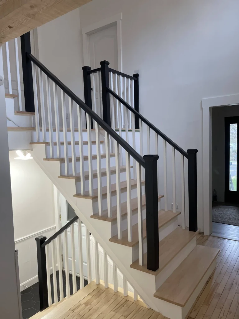 Escalier tournant à barreaux tournés blancs et poteaux noirs à Saint-Hubert