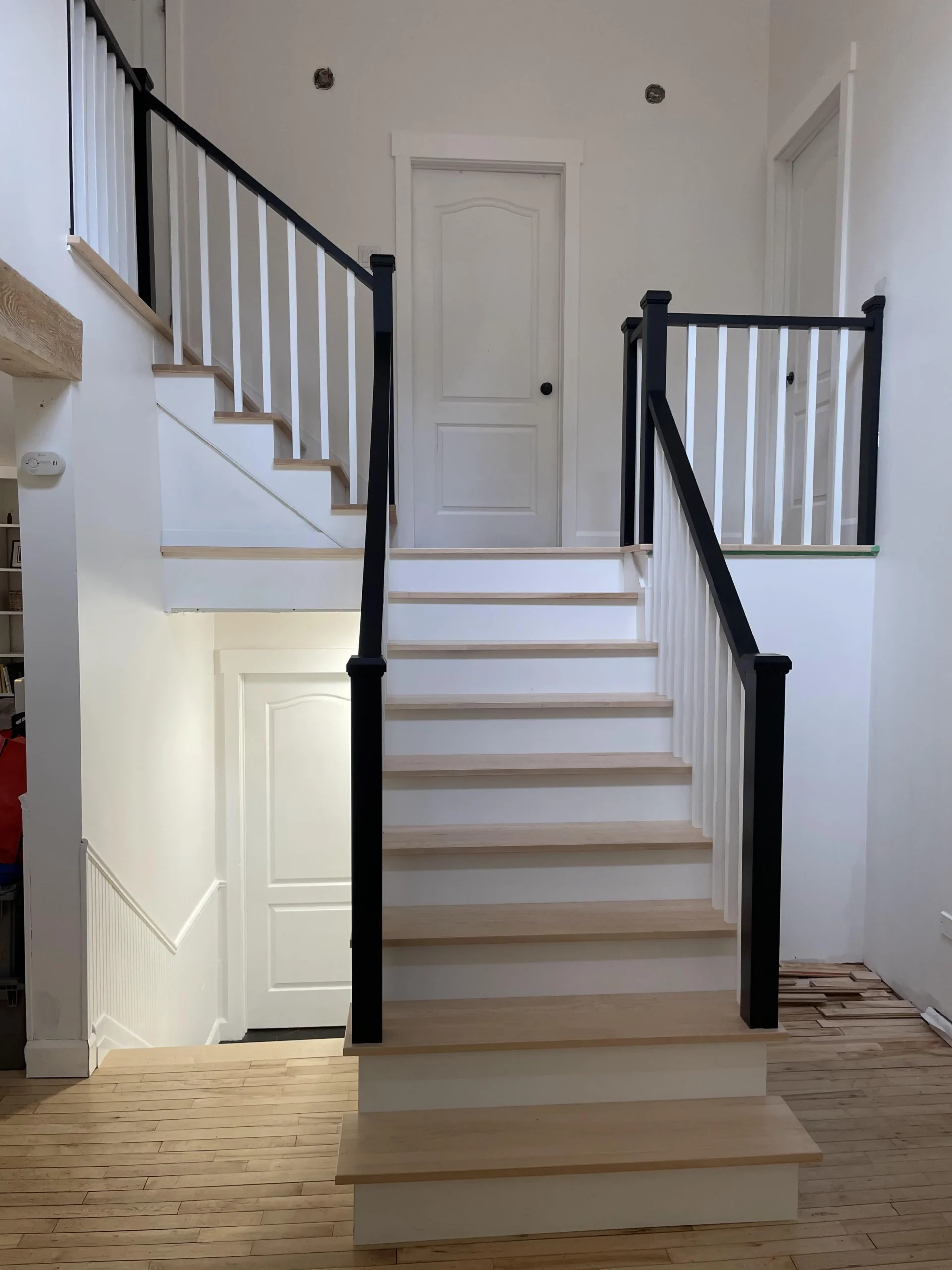 Escalier tournant à barreaux de bois tournés et poteaux noirs — vue principale